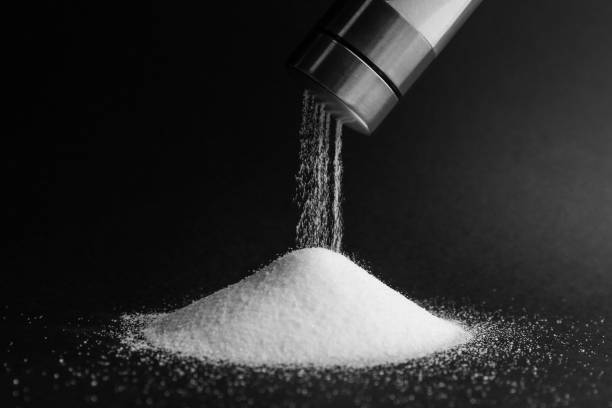 pouring salt from shaker on black background, closeup - saleiro de mesa imagens e fotografias de stock