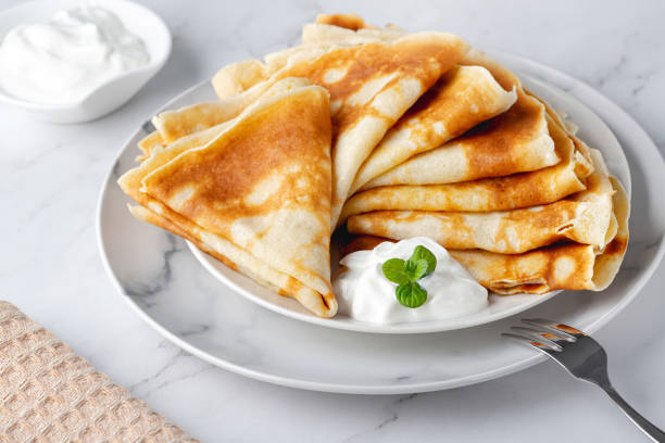 istock Stack of russian thin pancakes blini with fresh sour cream 1374978684