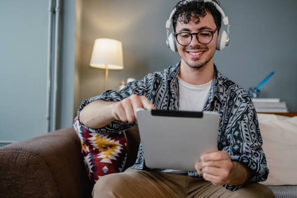 istock Young man enjoying reading internet content on a digital tablet 1374991811