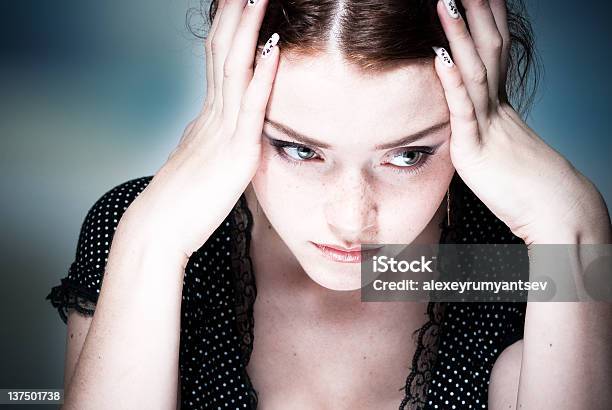 Young Lady Concentrating With Her Head In Her Hands Stock Photo - Download Image Now