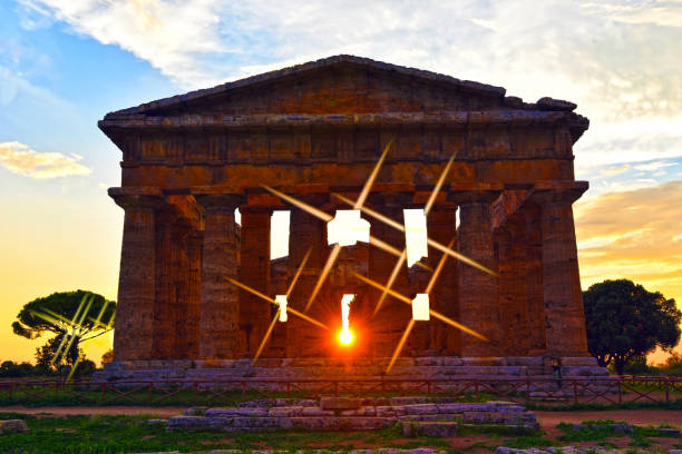 Historic Temple of Juno located in Agrigento, Sicily, basking in golden sunlight and standing tall against a vivid blue sky, highlighting its ancient architectural magnificence.