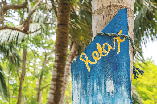 Relax sign located on a palm tree at a tropical island in Colombia Caribbean Coast