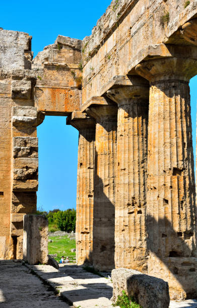 Sun shining over the rim of the roof of ruins of one of the Greek temples (Hera 1, Hera 2 and Athena) in Paestum, province of Salerno, Italy a former major ancient Greek city on the coast of the Tyrrhenian Sea