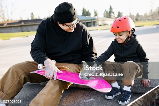 istock Father Skateboarding With His Son 1375026025