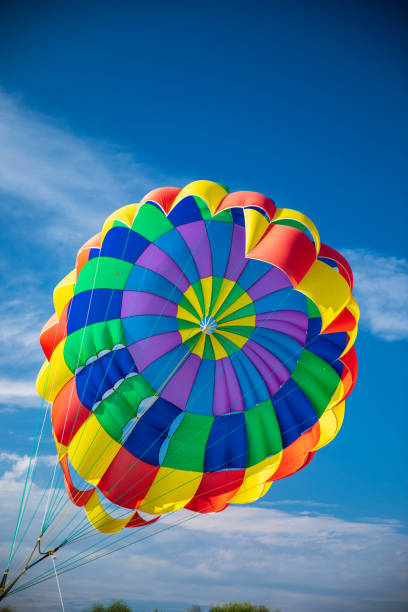 istock A multi-colored fluttering parachute against a blue sky with cirrus clouds. Parasailing 1375026106