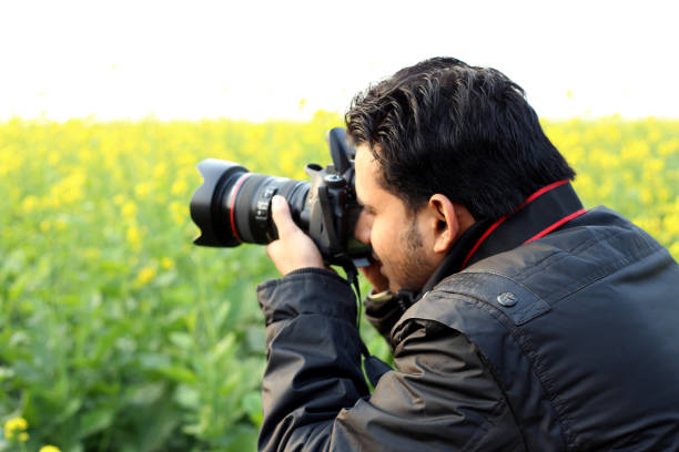 Photographer clicking photo in the field during SLR camera.