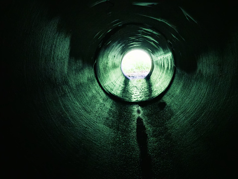 Drainage pipe under the highway (culvert). Filming inside the pipe.