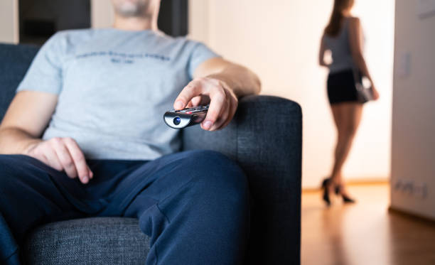 pareja distante se ignora. pelea, crisis o pelea. antisocial aburrido perezoso viendo la televisión. mujer solitaria y furtiva que se va de fiesta o engaña con un amante secreto. - television boredom men sofa fotografías e imágenes de stock