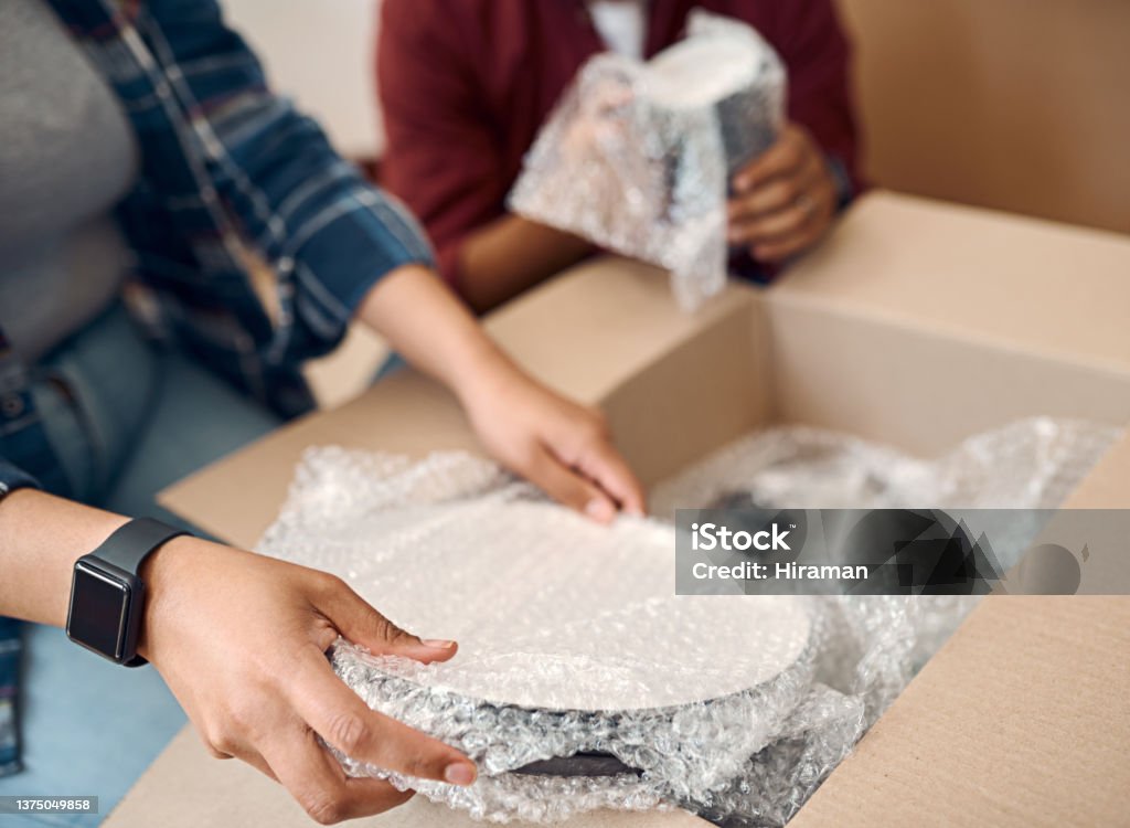 Shot of a young couple unpacking boxes in their new home Let's start with the kitchen Box - Container Stock Photo