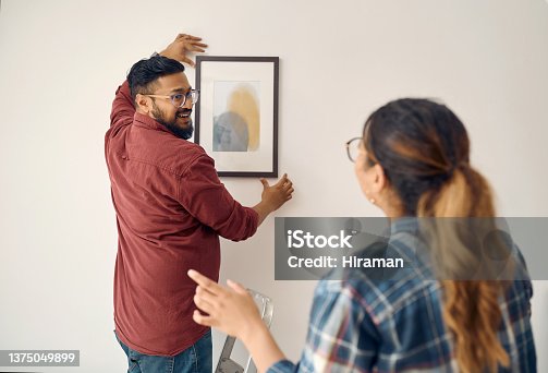 istock Shot of a young couple decorating their house together 1375049899