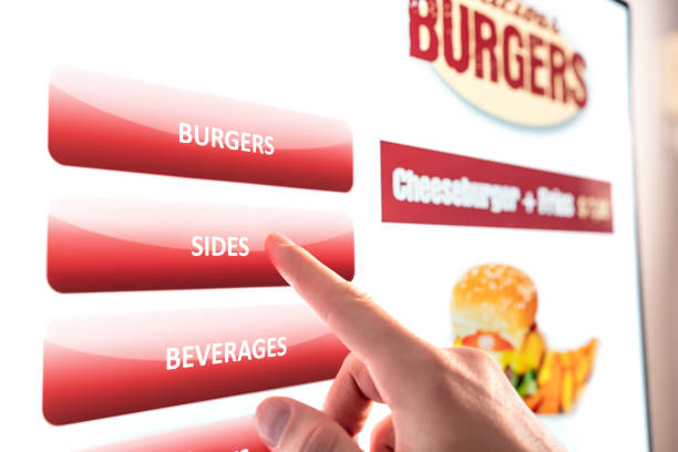 Self service and order kiosk in restaurant. Fast food touch screen, digital vending machine. Man using electronic menu and buying burger meal and paying with selfservice technology.