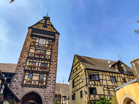 Riquewihr, France - September 15 2021: Beautiful houses from Alsace under blue sky in typic village of Riquewihr