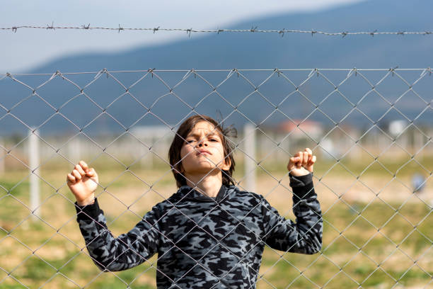 istock Little boy behind the fence 1375061771