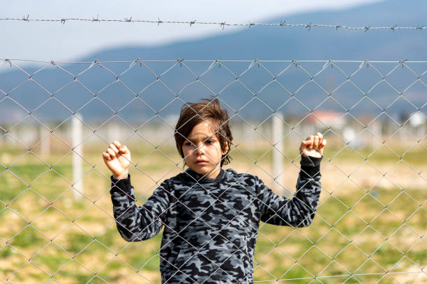 istock Little boy behind the fence 1375061843
