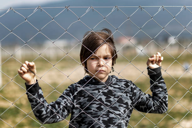 istock Little boy behind the fence 1375061883
