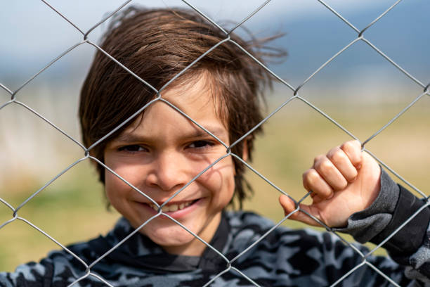 istock Little boy behind the fence 1375062021
