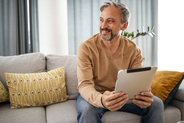 istock Modern middle aged businessman using digital tablet at home 1375063048