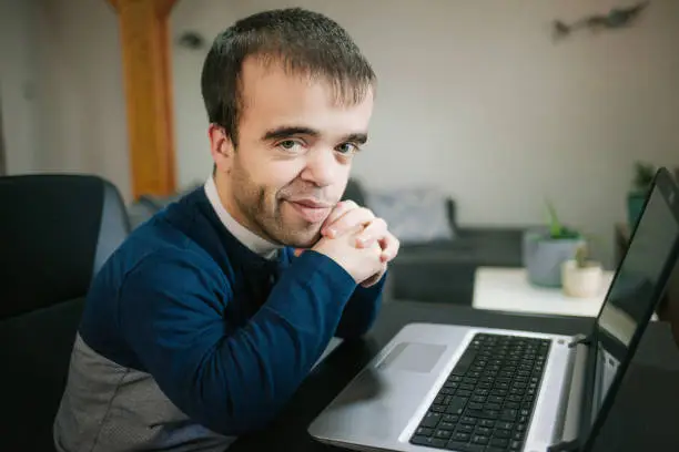 Young man with dwarfism working from home