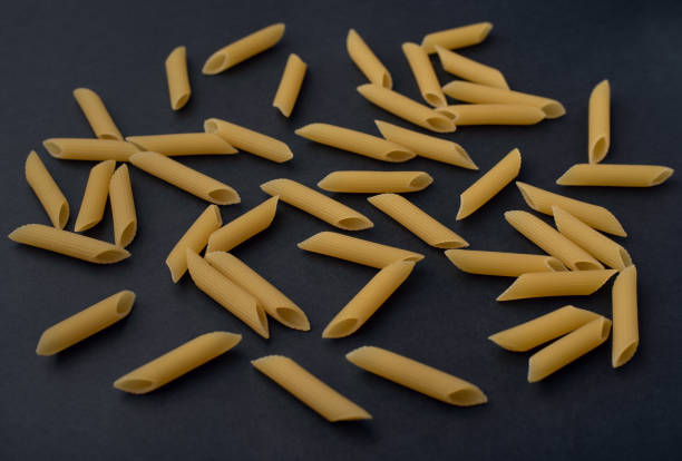 istock Raw pasta scattered on a dark background 1375082611