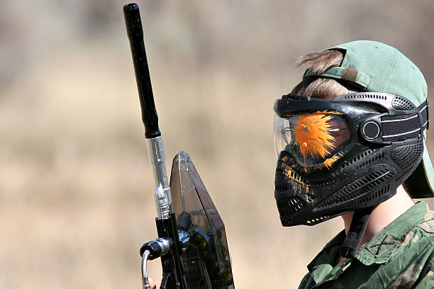 paintball - gotcha paintball player with mask after being hit in the head paintballing stock pictures, royalty-free photos & images