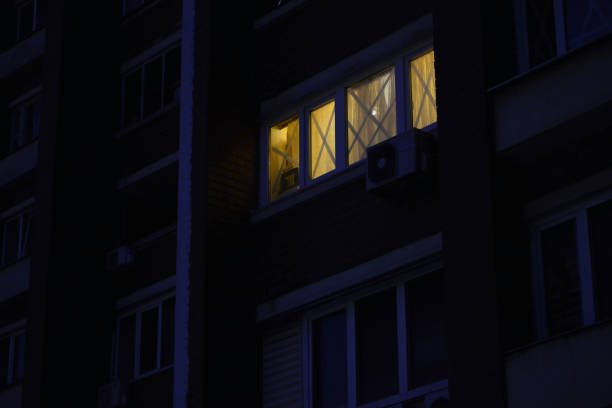 Light in the window at night, which is taped to prevent the formation of broken glass. Kyiv/Ukraine - 28 February 2022: War Ukraine Russia. Light in the window at night, which is taped to prevent the formation of broken glass. military invasion stock pictures, royalty-free photos & images