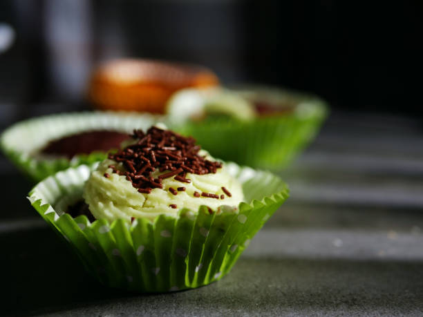 Cupcake decorated with frosting and chocolate sprinkles medium shot slow motion selective focus