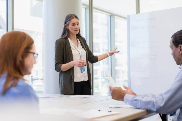 istock Female financial advisor gestures to whiteboard 1375143143