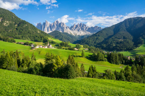 verdes prados herbosos en el pueblo de santa maddalena contra los grandes picos del grupo odle, val di funes, dolomitas. - montañas dolomita fotografías e imágenes de stock