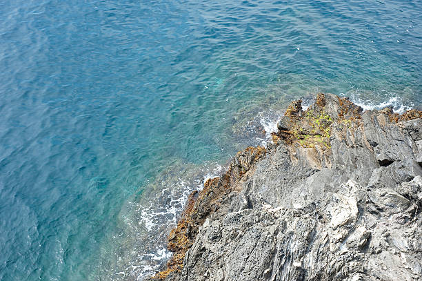 Rocky coast and cliffs of the Mediterranean sea in Liguria Italy (Ligurian sea),  near the small Village of Framura (Cinque Terre). La Spezia, Liguria, Italy, Europe.