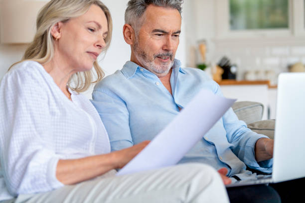 istock Mature couple doing paperwork with a laptop at home. 1375183414