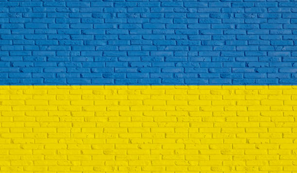 pared de ladrillo en azul y amarillo los colores nacionales de ucrania. - ukraine war fotografías e imágenes de stock