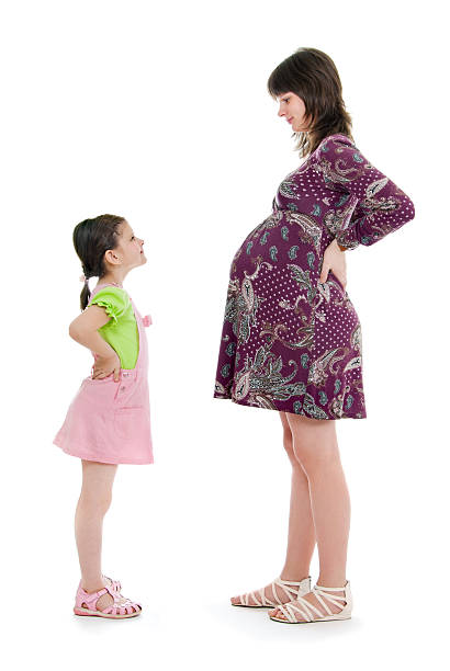 Pregnant mum costs opposite to the daughter, stock photo