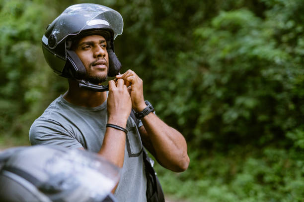 motociclista che indossa il casco nel parco naturale - casco protettivo da sport foto e immagini stock