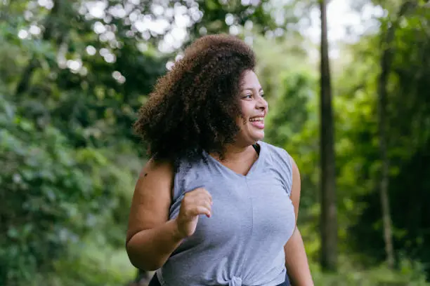 Photo of Plus size woman running in the natural park