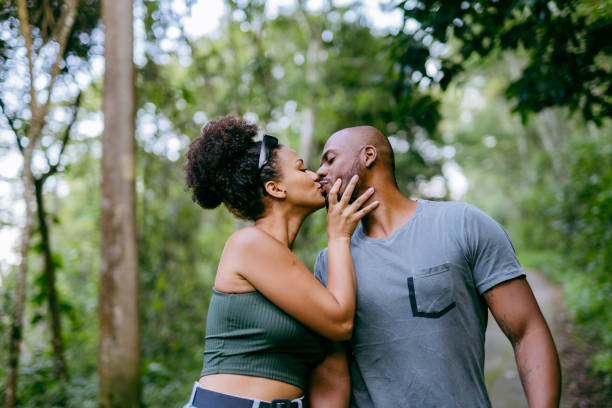 afroamerikanisches paar im naturpark - auf den mund küssen stock-fotos und bilder