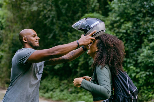 istock Woman putting on helmet to ride by motorcycle 1375210932