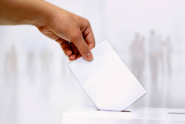 istock Male hand putting voting ballot into the vote box 1375211564