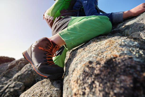 istock Unrecognizable boy with backpack climbing rocks in nature 1375230774