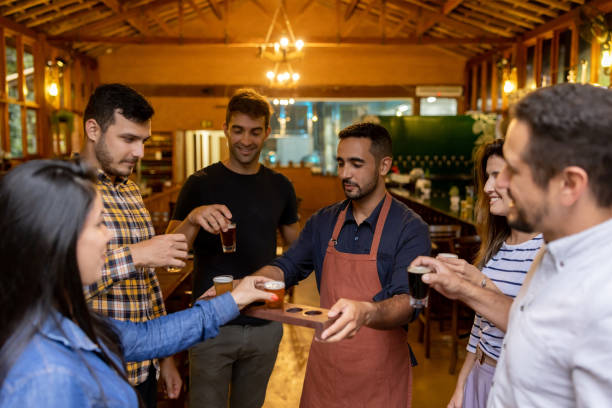 Group of people drinking samples of beer after taking a tour at a brewery Happy group of Brazilian people drinking samples of beer after taking a tour at an artisanal brewery distillery stock pictures, royalty-free photos & images