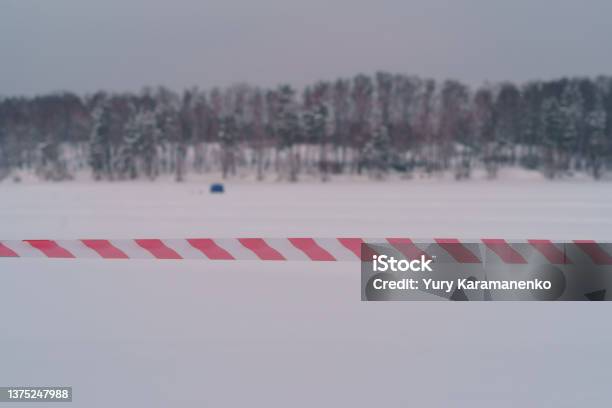Red And White Barrier Tape In Front Of Frosen River Stock Photo - Download Image Now