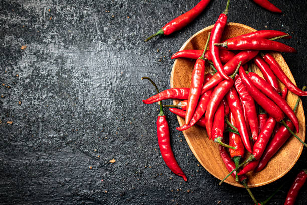 istock Chili peppers on a wooden plate. 1375257700