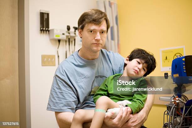 Preocupado Padre Sostiene A Su Hijo En El Hospital Vomitar Para Personas Con Discapacidades Foto de stock y más banco de imágenes de Tristeza