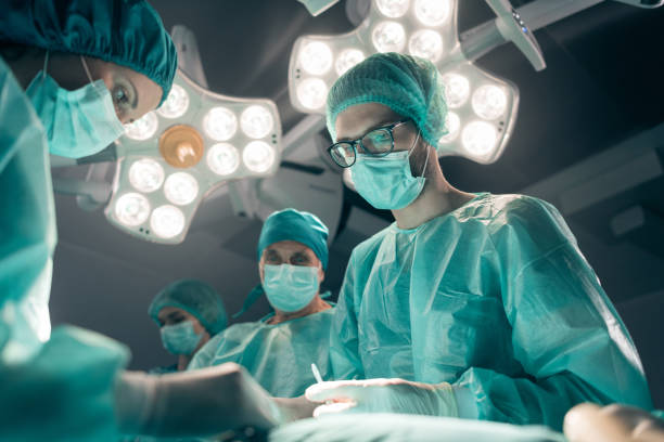 Young surgeon performing surgical operation stock photo