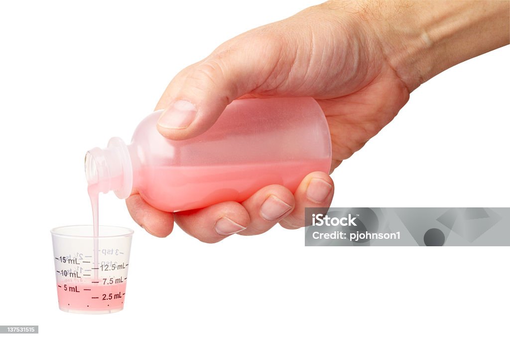 Kids medicine Hand pouring children's medicine into metric graduated cup.  Larger files come with clipping path. Aspirin Stock Photo