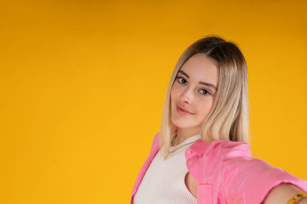 istock young woman taking a selfie with her smartphone.Studio photography 1375325183