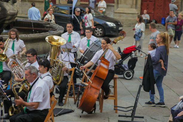 2018 June 23. Spain. Santiago de Compostela. Concert of classical music, on the square near the cathedral. Residents of the city, pilgrims and just tourists watching and enjoying the music.