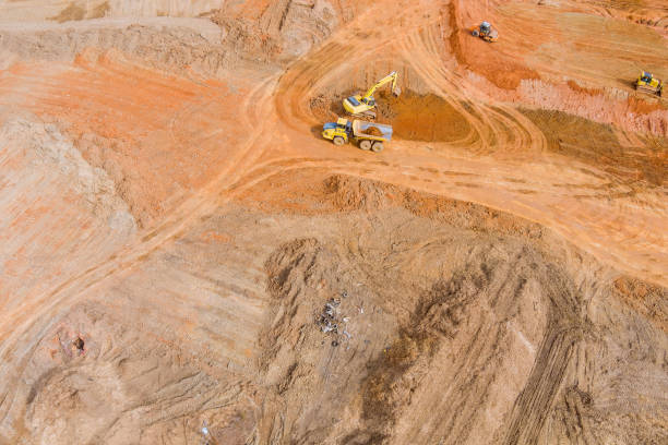 istock Aerial top view at excavator loads earth into a large dump truck with construction site 1375346682