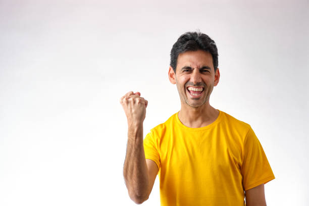 dark-haired man making victory gesture with his arm