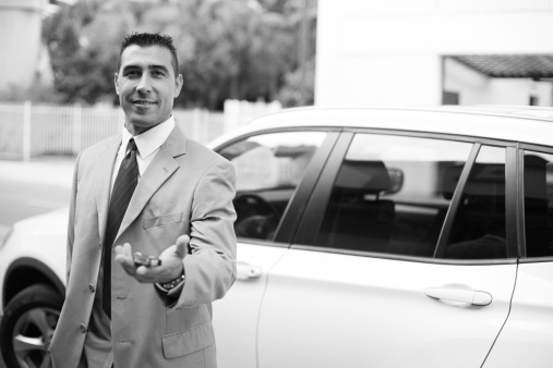 Image of a handsome businessman handing the keys to his vehicle