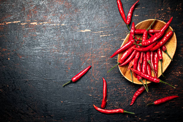istock Wooden plate with hot chili peppers. 1375376164
